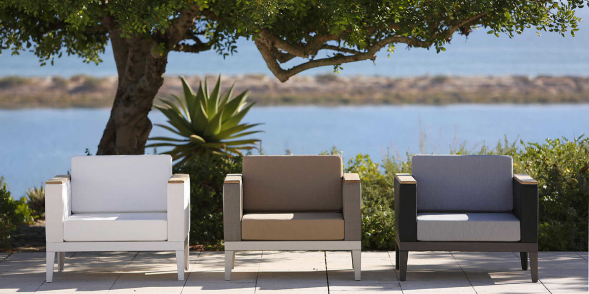 Barlow Tyrie Aura Deep Seating armchairs on patio by the sea