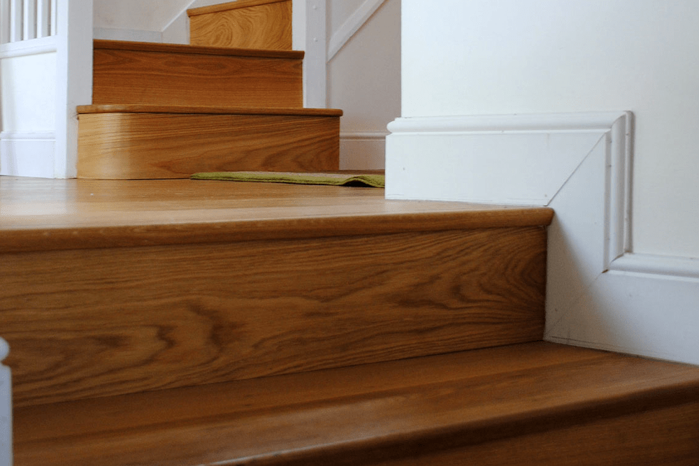 Standard softwood staircase given facelift by cladding with engineered Oak boards, finished with a solid Oak nosing to match.